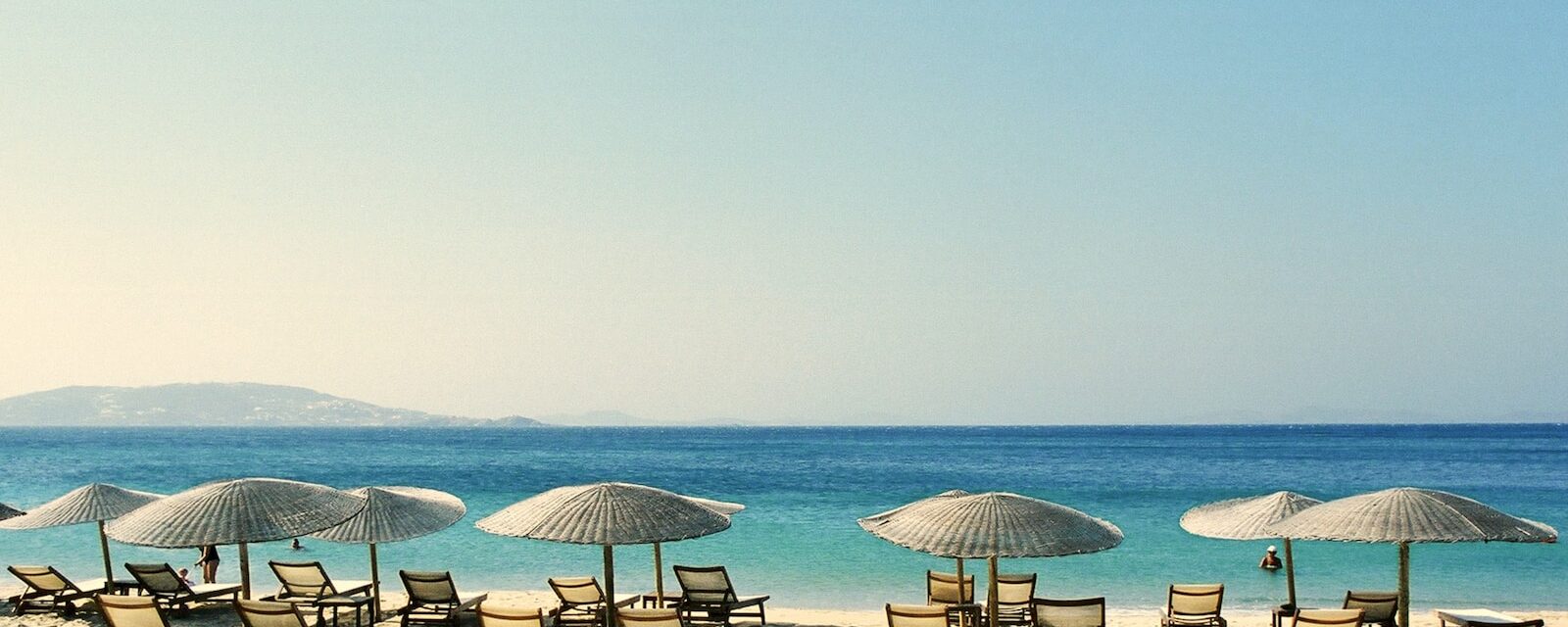 white and blue beach chairs on beach during daytime