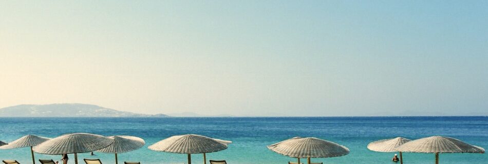white and blue beach chairs on beach during daytime