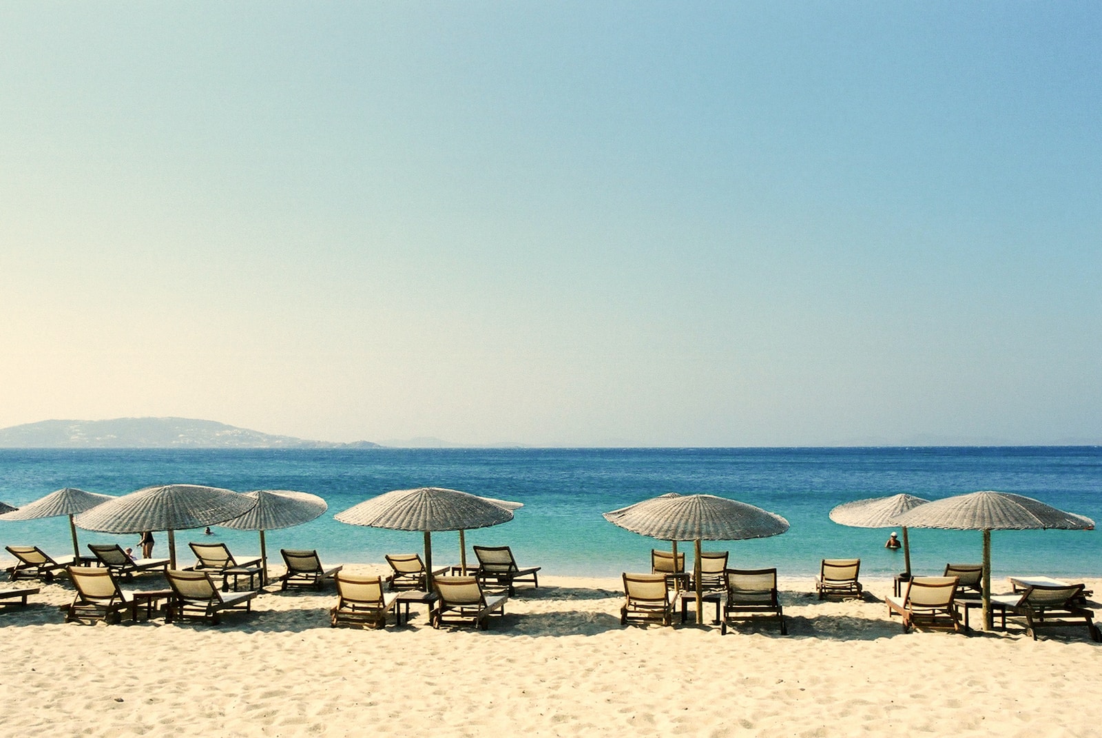 white and blue beach chairs on beach during daytime