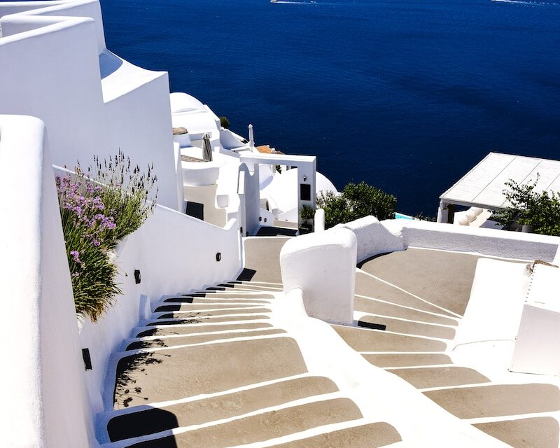 a white staircase leading down to a body of water