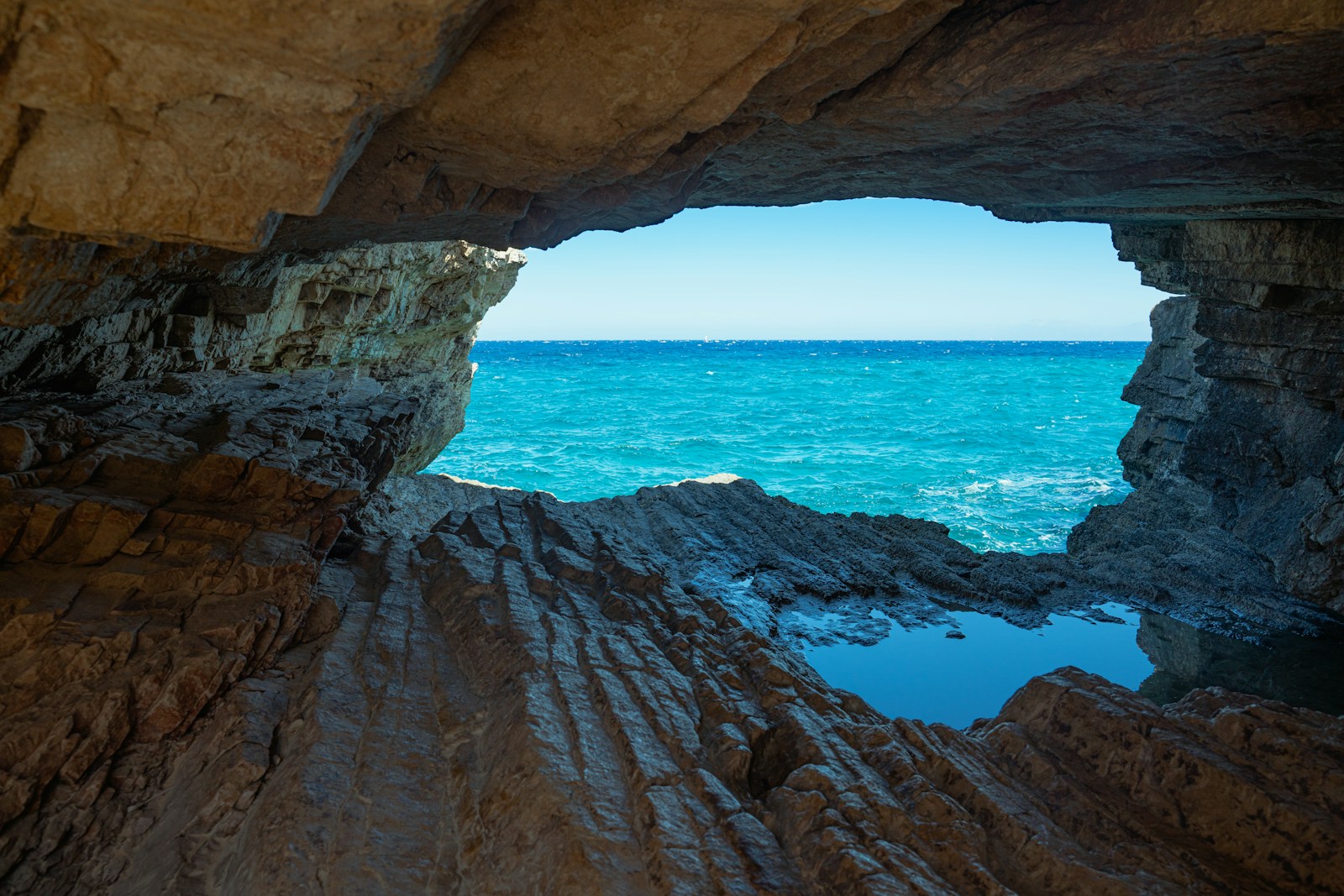 brown rock formation near blue sea during daytime