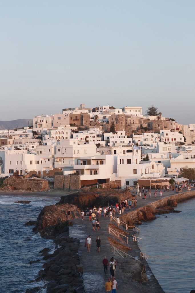 a group of people walking along a beach next to the ocean